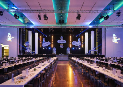 Blick in einen Saal für eine Karnevalssitzung. M4E Veranstaltungstechnik Siegburg hat für die unken Blau-Weisseine schöne Dekoration, stimmungsvolle Beleuchtung und eine passende Tonanlage geliefert.