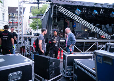 Bühnentechniker beim Aufbau der Veranstaltungsbühne für ein großes Open Air Konzert in Siegburg. Die Leistungen der M4E Veranstaltungstechnik beinhalten Ton, Licht, Bühne, Rigging und Videoaufnahme.
